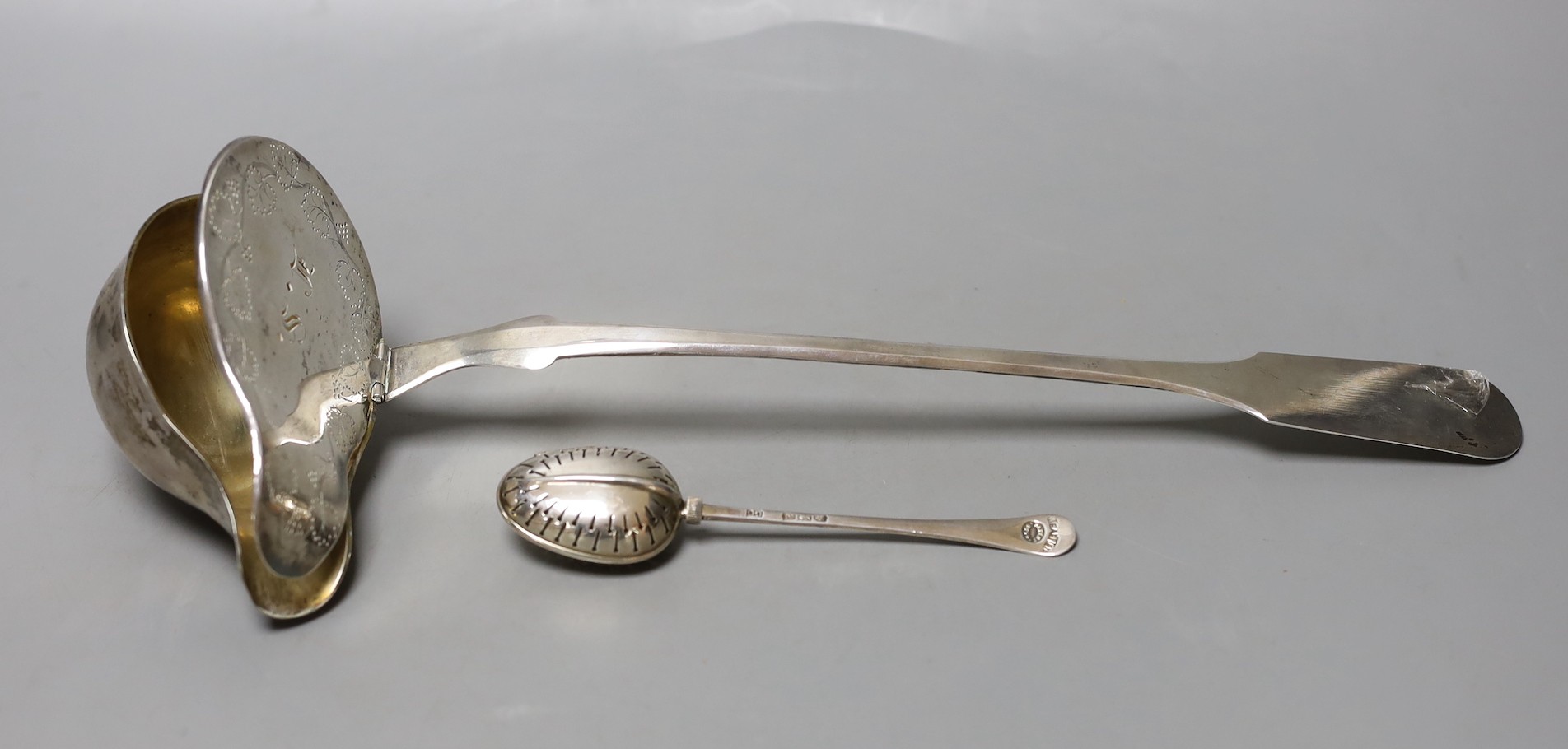 A 19th century continental white metal serving ladle, 36cm and a late Victorian silver tea infuser, gross 216 grams.